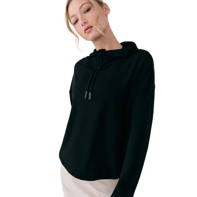 A woman models the Lole Dynamic Hoodie—a black, breathable knit style with drawstrings—against a plain white background.