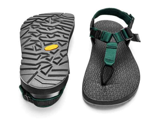 A pair of Bedrock Carin Evo 3D Pro sandals in black and green—one displays the textured Vibram Megagrip sole with a yellow logo, the other shows adjustable top straps for a secure fit.