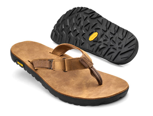 A pair of Bedrock Rockhound Sandal - Nubuck Leather in brown, featuring black Vibram soles; one sandal shown from the top and one from the bottom to highlight the tread pattern and supportive footbed.