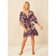 A woman wearing the Maaji Divinity Dress, a purple floral mini dress.
