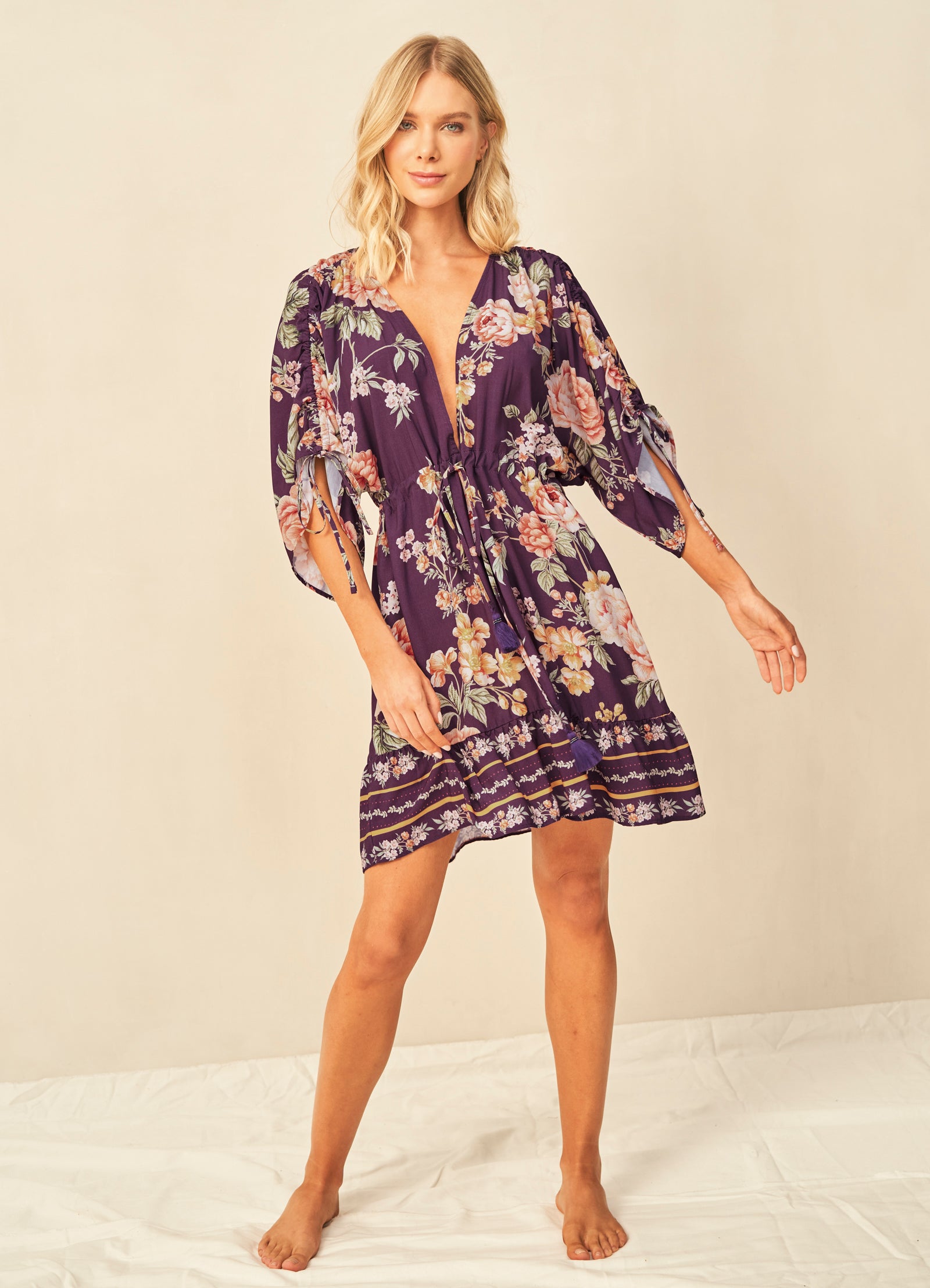 A woman wearing the Maaji Divinity Dress, a purple floral mini dress.