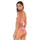 A woman faces away, looking over her shoulder, wearing the Maaji Flirt Bottom—a pink and orange floral high-leg bandeau bikini—set against a plain white background.
