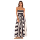 A person is wearing the Stripes Ela Long Dress by Maaji, a sleeveless black and white striped maxi dress, while standing against a plain white background.