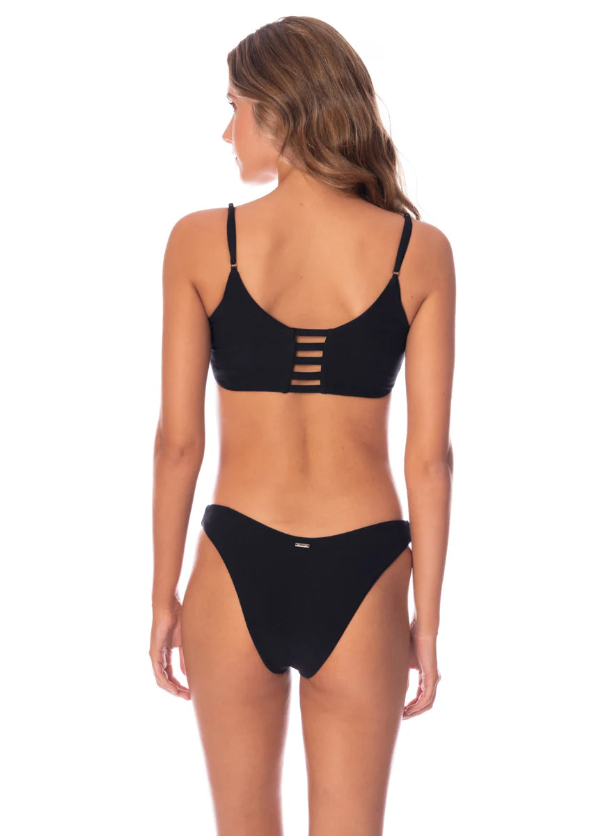 A person models the Maaji Splendour bikini with a strappy back design in black, set against a white background.