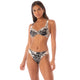 Someone models the Maaji Archie Top, a black and white floral bikini, standing with their hands at their sides against a plain background.