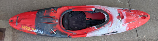 A Used Pyranha Machno whitewater kayak from 4Corners Riversports, featuring a red and black design, rests on a concrete surface as seen from above.