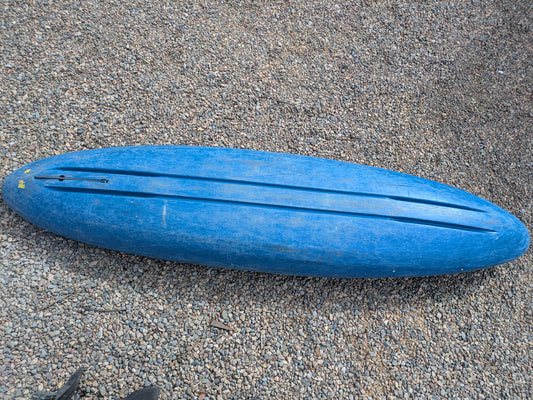 A used Consignment LiquidLogic XP9 kayak by LiquidLogic, blue in color, lies upside down on a bed of small brown pebbles.