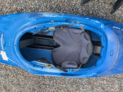 A Consignment Wavesport ZG by Wavesport, a blue freestyle kayak with open cockpit and padded seat, is pictured resting on gravel.