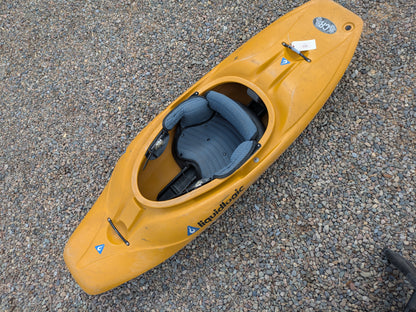 A Wavesport Consignment LiquidLogic CR125 river runner kayak with a padded seat is resting on a gravel surface.