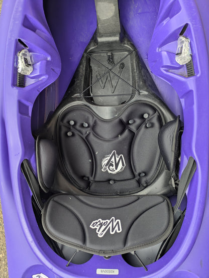 Top-down view of the padded seat and foot area inside a purple Demo Skuxx kayak by Waka Kayaks, with the Wave logo visible on the seat back and cushion.