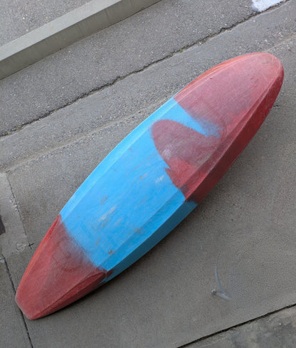 A Consignment Medium Ozone from 4Corners Riversports, with faded red and blue paint, lies upside down on concrete near steps, capturing the adventurous spirit of slicey river running.