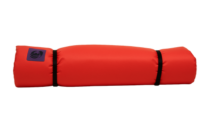 The Jacks Plastic Welding Pickup Paco Pad is a bright red cylindrical camping mattress with black end straps and a small purple logo on one side, shown against a white background.