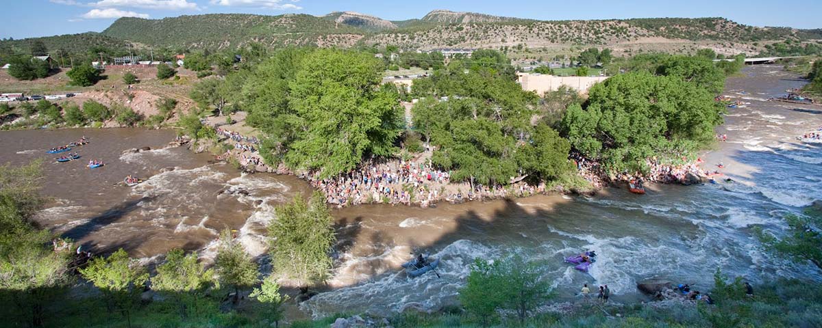 a group of people standing on top of a river.