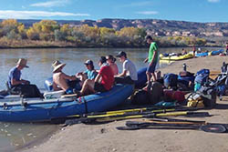 a group of people sitting on top of a blue boat.
