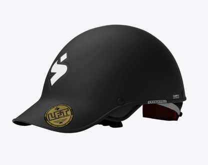 The Sweet Protection Strutter Helmet is a matte black whitewater helmet with a small visor, a white logo on the side, and a gold certification sticker on the front.