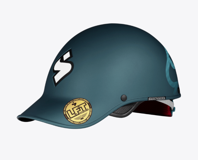 The Strutter Helmet by Sweet Protection is a matte teal playboating helmet featuring a large white "S" logo on the front and a round gold certification sticker on the brim.