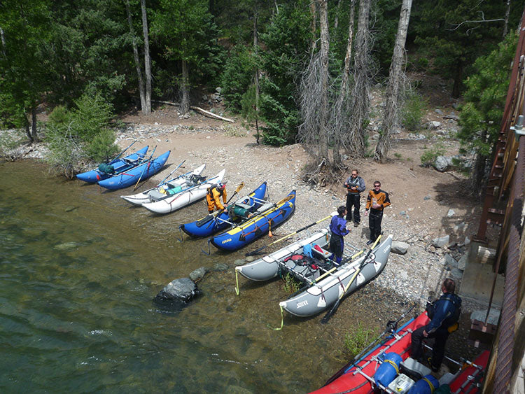 a group of people standing next to a bunch of boats.