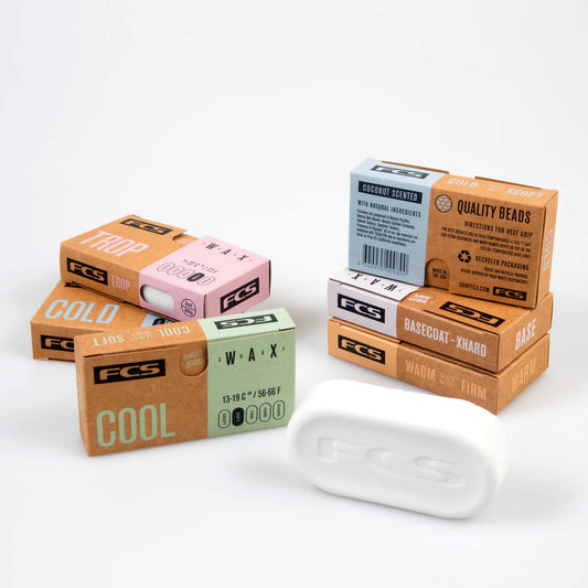 A box of FCS Surfboard Wax with different types of soap on it.