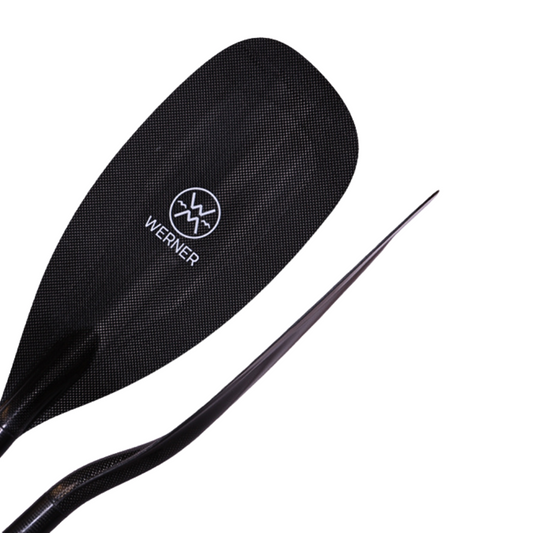 The Covert kayak paddle by Werner Paddles features a stealth blade design, perfect for racing, with a curved carbon fiber blade ensuring optimal performance and efficiency on the water.