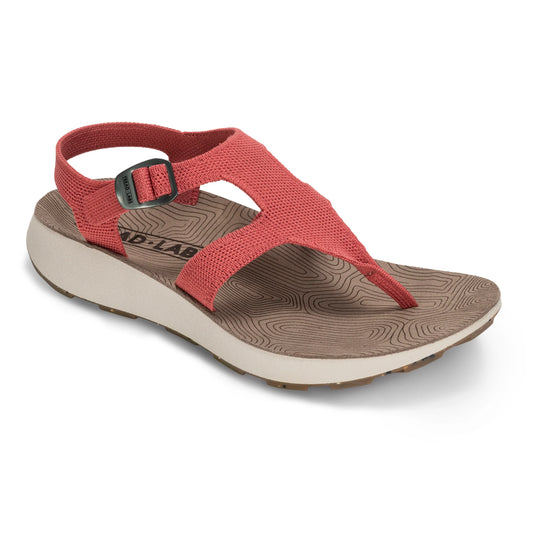 The Tread Labs Women's Albion Sandal features a red fabric upper, buckle strap, brown contoured sole with a topographic pattern, and open toe—ideal for durable off-trail hiking adventures.