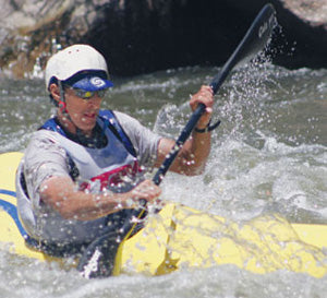 a man riding a kayak on top of a river.