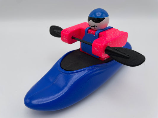 A Foamie Friends figure expertly maneuvers the Foamie Play Boat, holding a black paddle and dressed in a red vest and blue cap, eager to delve into the wonders of river dynamics.