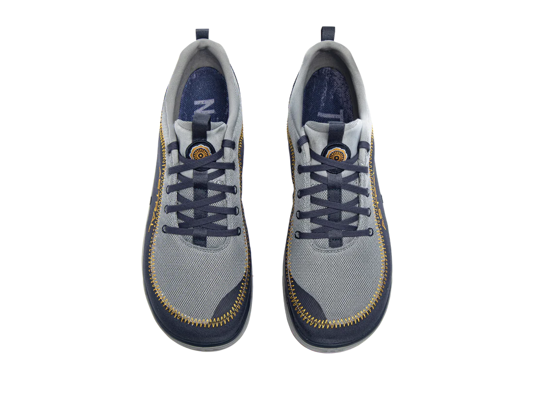 Top view of a pair of Brewer 3.0 sneakers by Astral, featuring a gray and navy color scheme with hydrophobic canvas ideal for kayakers, a zippered design around the sole and eyelets, and branded logo on the tongue.