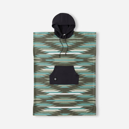 The Nomadix Changing Poncho features a geometric green and blue design, black hood with drawstrings, and a spacious front pocket, shown against a plain background.