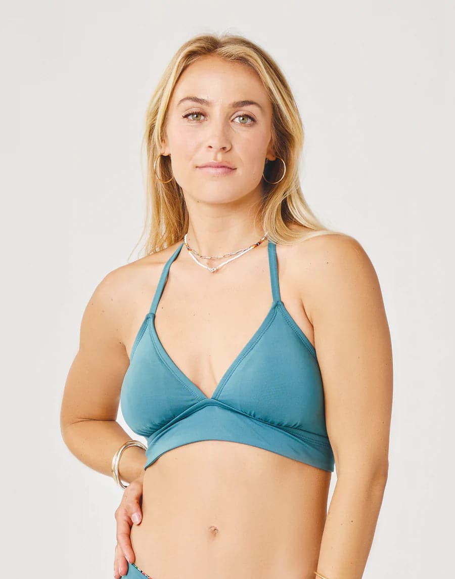 A woman in a blue Carve Dahlia Top bikini posing for a picture.