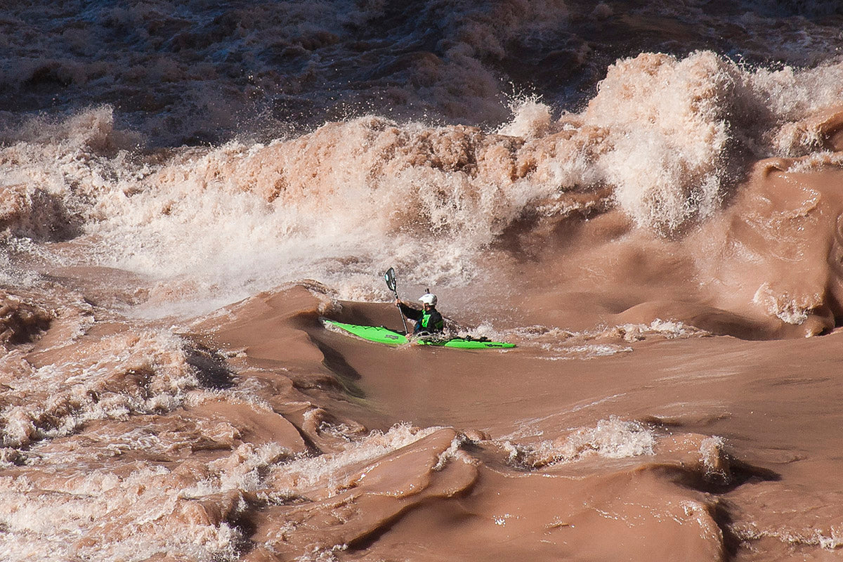 a man riding a green surfboard on top of a wave.
