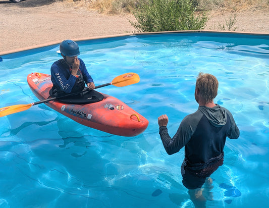 At the Durango Recreation Center, one person floats in a kayak while another stands nearby as they take part in the 4CRS Paddle School's Winter Roll Session for private roll and kayak rolling instruction.