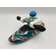 A Foamie Friends Swirl Play Foamie Boaters figure with a blue helmet and paddle sits in a marbled teal, white, and orange plastic play kayak against a plain background.