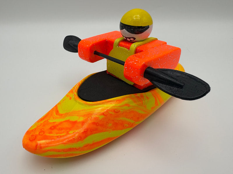 The Foamie Friends Swirl Play Foamie Boaters features a toy figure in an orange life jacket and yellow helmet, sitting in a vibrant orange and yellow boat with a black paddle—perfect for imaginative water play.