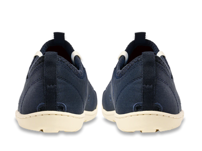 Rear view of the Astral Loyak - Women's navy blue slip-on shoes with white soles, featuring a FlexGrip outsole ideal for kayaking, against a white background.