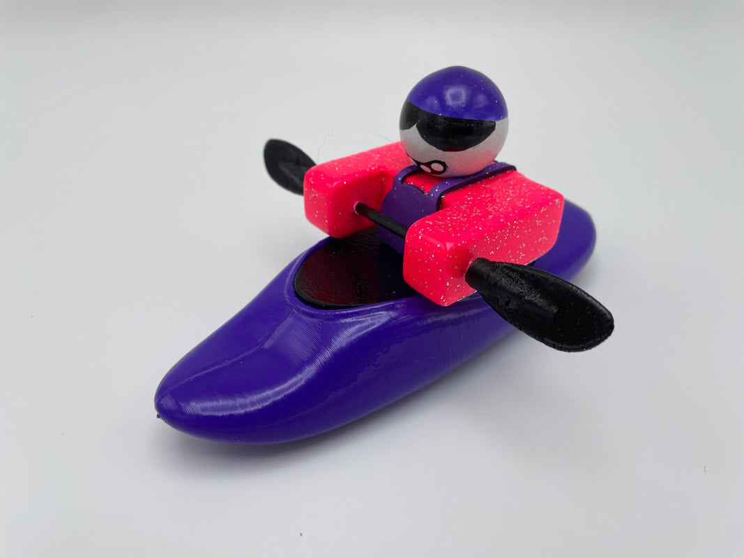 This Foamie Friends toy figure features a colorful kayaker dressed in a purple kayak and helmet, with a pink torso and holding a paddle. Ideal for Mini Playboat enthusiasts, the Foamie Mini Playboat highlights an impressive hull design perfect for River Running adventures.