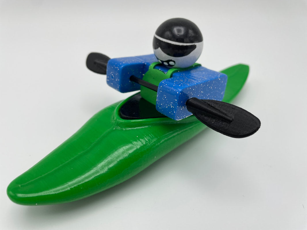 The Foamie Friends' Foamie Mini Slice provides an exhilarating performance for adventurers, featuring a toy figure adorned with a stylish helmet and sunglasses. Positioned in a green kayak, the figure deftly maneuvers through the water using black paddles—showcasing the kayak's innovative hull design.