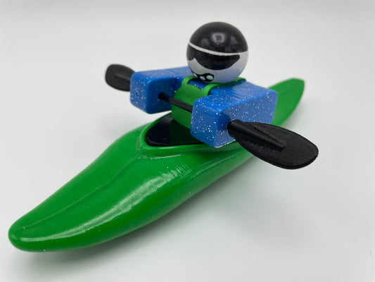 The Foamie Friends' Foamie Mini Slice provides an exhilarating performance for adventurers, featuring a toy figure adorned with a stylish helmet and sunglasses. Positioned in a green kayak, the figure deftly maneuvers through the water using black paddles—showcasing the kayak's innovative hull design.