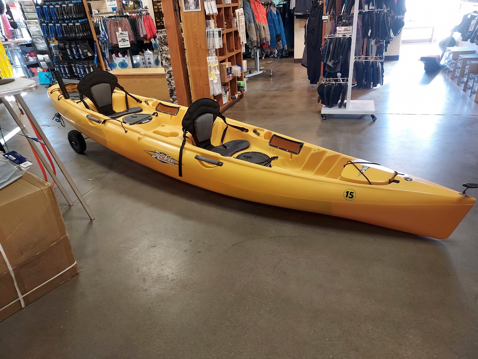 A yellow Consignment Hobie Mirage Oasis kayak sitting in a 4CRS store.