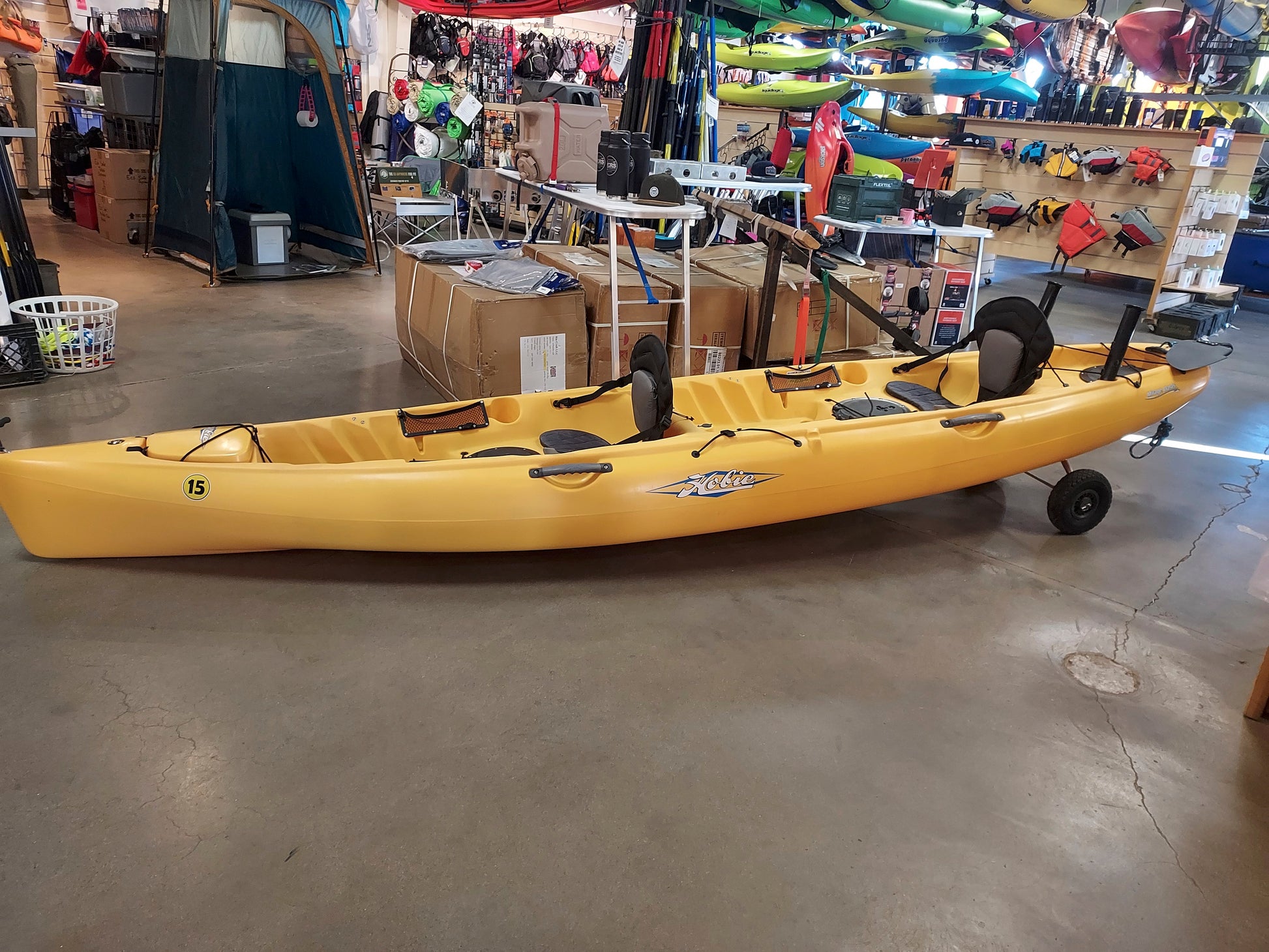 A yellow Consignment Hobie Mirage Oasis kayak sitting in a 4CRS store.