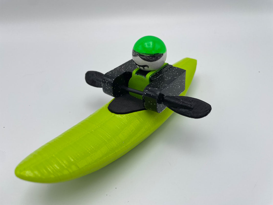 Introducing the Foamie Friends Foamie Mini Creeker, designed for river adventures! This toy figure comes equipped with a green kayak and black paddles, complemented by a matching green helmet, all set against a crisp white backdrop.