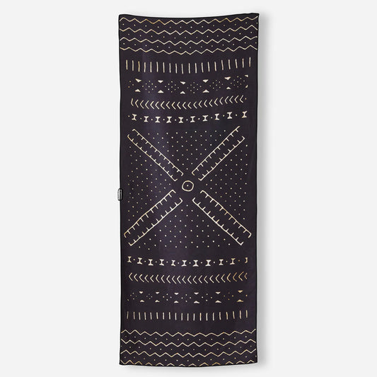 The Nomadix Original Towel features a rectangular black design with beige geometric and tribal-inspired patterns. Perfect as a sand-resistant or stylish travel towel for your next adventure.