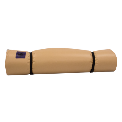 The Jacks Plastic Welding Pickup Paco Pad is a tan waterproof camping mattress, rolled up and secured with two black straps. A small purple label is on one end, shown against a plain white background.