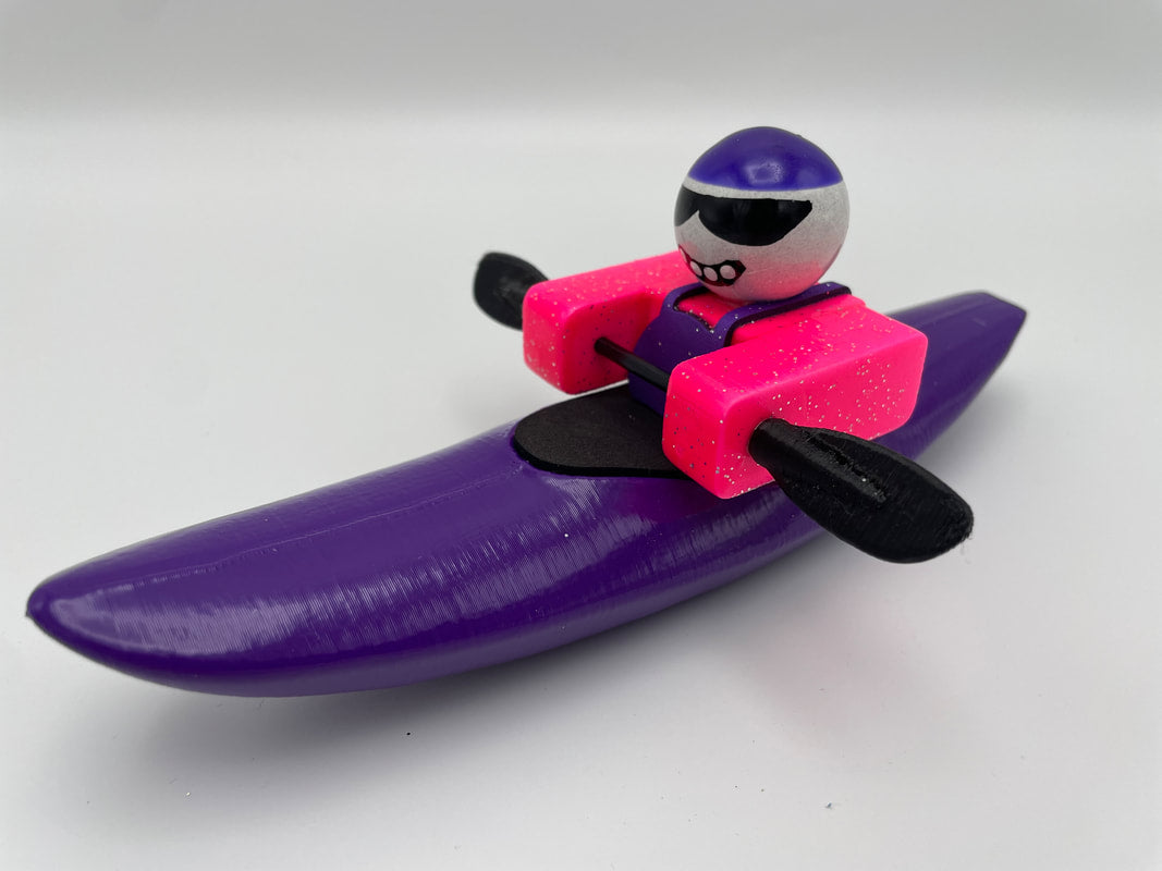 The Foamie Mini Creeker by Foamie Friends includes a purple and pink toy kayak, along with a figure equipped with sunglasses, a helmet, and paddles, perfect for river play adventures.