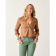 A person with long hair is smiling against a plain background, wearing a Dylan Textured Shirt by Carve and green pants.