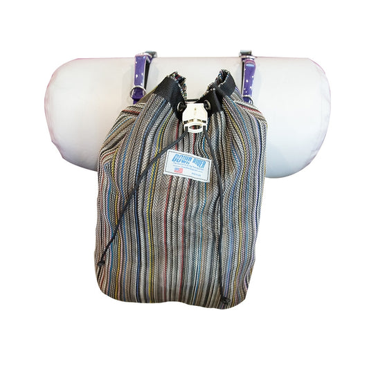 A Thwart Bag by Down River Equipment, featuring a striped UV-resistant, quick-access cinching system, hangs on a pole with a purple and white polka dot cushion behind it.