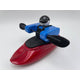 A Foamie Friends toy figure from the Foamie Spud Play Boat collection, dressed in a blue jacket and helmet, is seated in a red kayak. Designed for river dynamics enthusiasts, the figure grips black paddles against a white background.