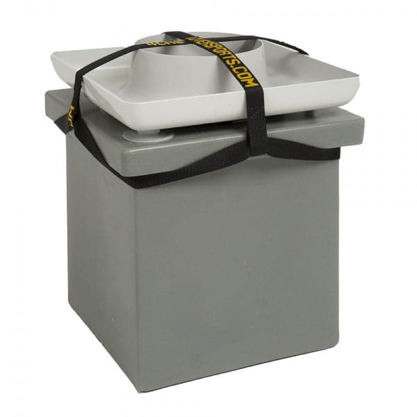 A gray, square boat anchor with a white plate on top and black straps with yellow text resembles the rugged design of the Coyote River Gear Portable Camp Toilet System II.