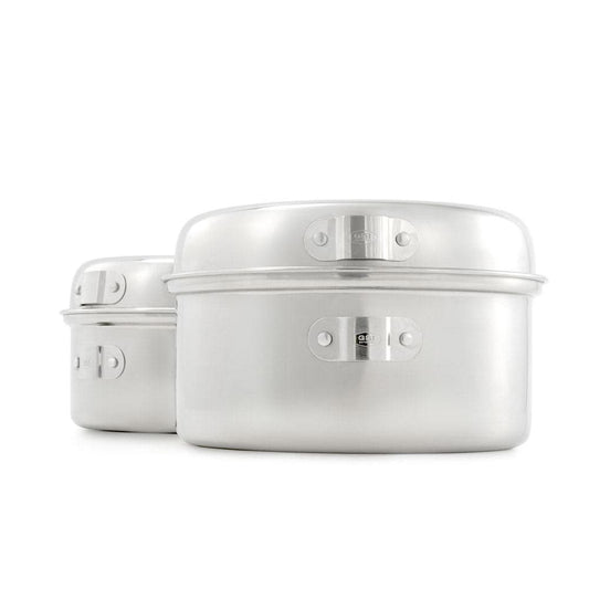 A pair of sleek, silver aluminum stackable cooking pots with latches is set against a white background, highlighting their compact design. Similar to GSI Outdoors' Glacier Stainless Cookset, they ensure durability and elegance for today's modern kitchen.