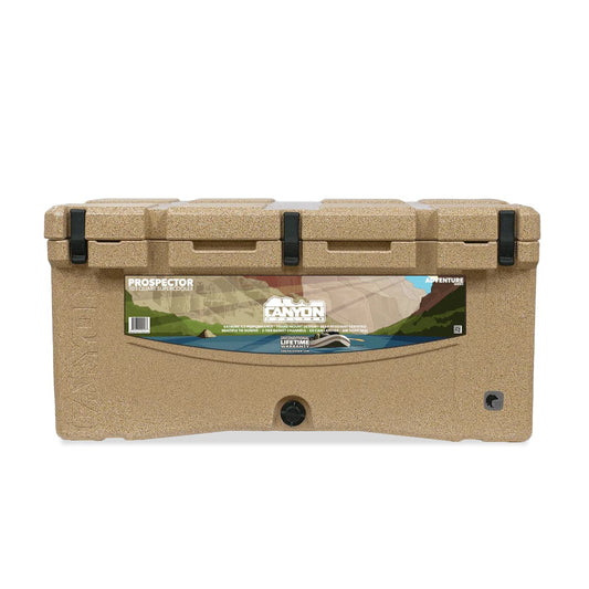 The tan Canyon Coolers' Prospector 103 Raft Cooler features a striking mountain landscape design and is bear-resistant, perfect for adventurous outings.