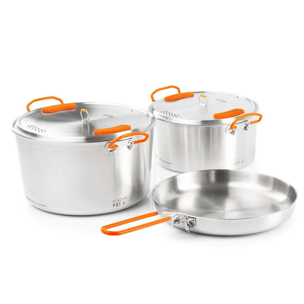 Introducing the Glacier Base Camper set by GSI Outdoors: three stainless steel pots with vibrant orange handles for gourmet cooking. This set includes a large pot, medium pot, and versatile frying pan, perfect for culinary adventures.